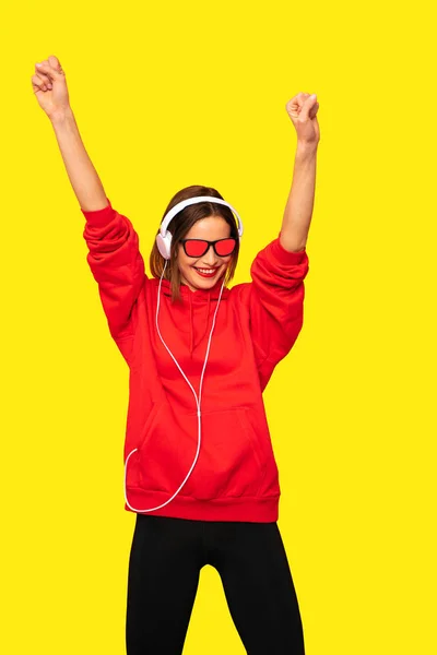 Ung Rebel Pige Rød Hættetrøje Med Hovedtelefoner Solbriller Lytter Musik - Stock-foto