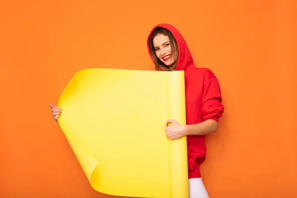 若者や流行に敏感な女の子の密着の黄色い空ロールを提示のオレンジ色の背景上のテキスト スペース — ストック写真