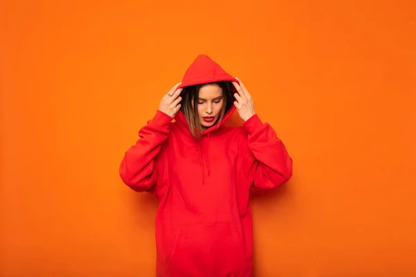 poz ya da bir şey bekliyor serin genç hipster sarı zemin üzerine kırmızı kukuletalı baş başlık ile