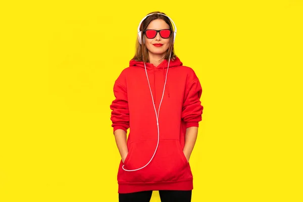 Jonge Rebel Meisje Rode Hoodie Met Hoofdtelefoons Zonnebril Luisteren Muziek — Stockfoto