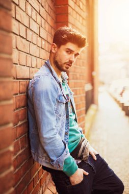 bir tuğla duvara poz ve kamera, osteopenik resim ile modern bir öğrenci için gülümseyen yakışıklı ve güzel genç adam