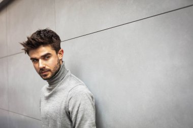 yanındaki gri bir modern duvar dışında poz serin bir adam portresi