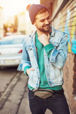 cool olmak hiç kolay, Genç sakallı bir serin genç gülümseme, modern yenilikçi kamera için poz olarak giyinmiş bir adamdı