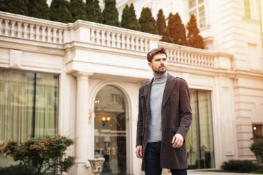 kendinden emin ve şık adam dışında bir otel ya da güzel bir eski bina önünde ayakta