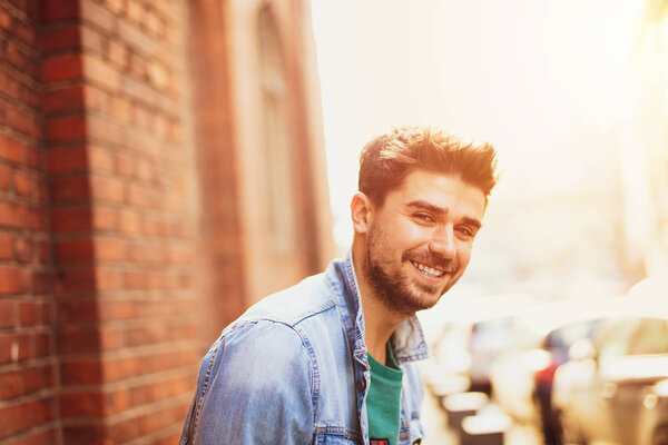 улыбчивый и счастливый крутой мужчина, глядя в камеру и весело проводя день, фотографируясь с современным парнем на улице
