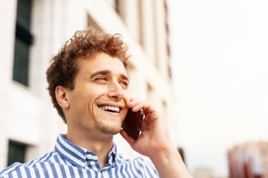 sevinçle cep telefonu konuşan adam