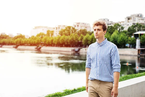 Inteligente chico casual teniendo un paseo clouse al río —  Fotos de Stock