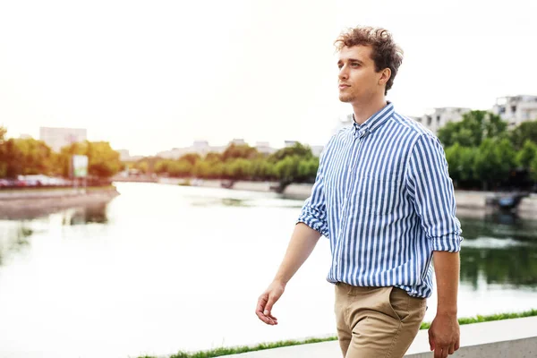 川への散歩のクロースを持つスマートなカジュアルな男 — ストック写真