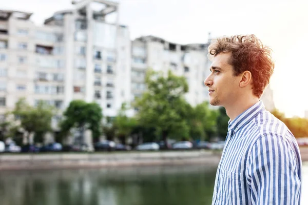 Intelligente ragazzo casuale avendo una passeggiata clouse al fiume — Foto Stock