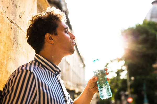 Jovem bebendo água lá fora — Fotografia de Stock