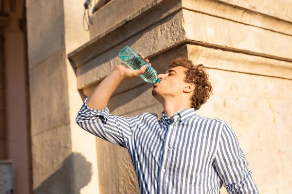 Young man drinking water outside — Stock Photo, Image