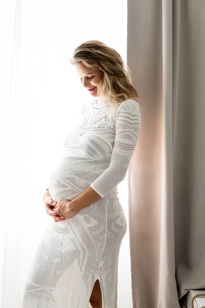 Беременная женщина сидит на кровати — стоковое фото