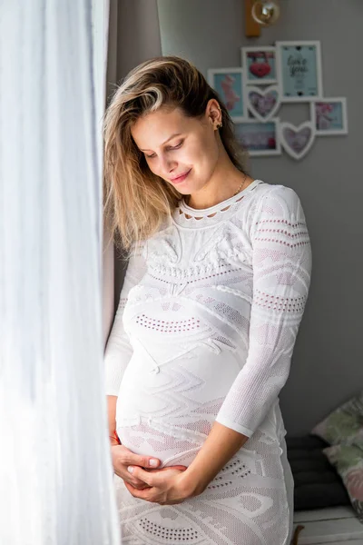 Těhotná žena, sedící na posteli — Stock fotografie