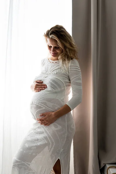Mulher grávida sentada em sua cama — Fotografia de Stock