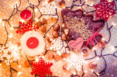 Noel gingerbread Noel ışıkları ve fındık ile çevrili kahverengi Festival arka plan üzerinde bulunan neşeli Noel etiket