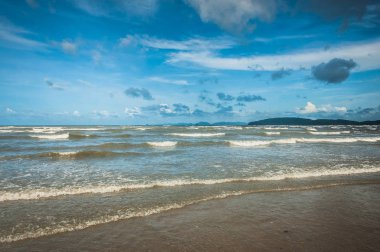 Arka planda küçük bulutlar ve mavi gökyüzü ile tropik Ocean beach