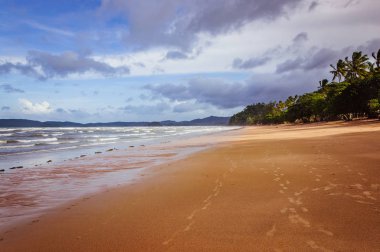Arka planda küçük bulutlar ve mavi gökyüzü ile tropik Ocean beach