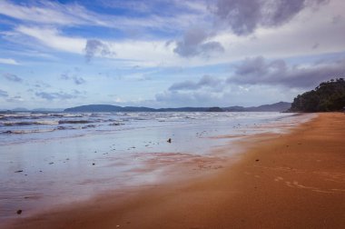Arka planda küçük bulutlar ve mavi gökyüzü ile tropik Ocean beach