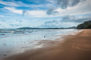 Arka planda küçük bulutlar ve mavi gökyüzü ile tropik Ocean beach