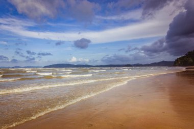 Arka planda küçük bulutlar ve mavi gökyüzü ile tropik Ocean beach