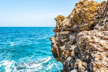 İtalya 'da açık mavi deniz suyu ve yaz güneşinin altında kocaman bir kaya
