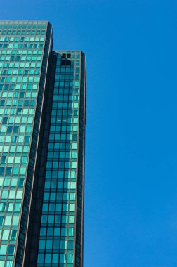 Arka planda mavi gökyüzü olan modern gökdelen