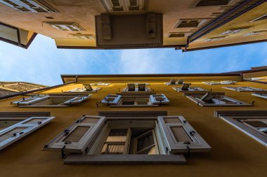 Güneşli bir havada mavi gökyüzü iki yakın sarı bina arasında