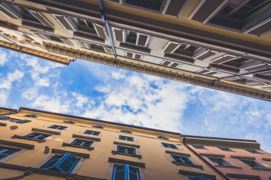 Kapalı panjurları olan iki İtalyan binası arasındaki göz alıcı mavi gökyüzü.