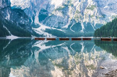 Sabah Braies Gölü 'nün sersemletici sisleri ve boş ahşap botlarla turistleri huzur içinde bekliyor.