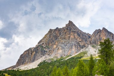 Görkemli Dolomitler, arka planda dramatik gökyüzü ile sallanırlar.
