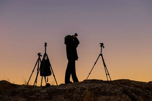 Silhouette eines Mannes am frühen Morgen mit einer Kamera. — Stockfoto