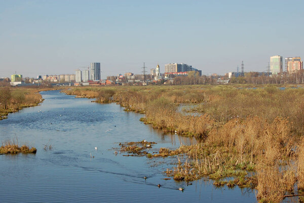 Panorama of the city of Mytischi behind the river Yauza and wetland landscape in national park Losiny Ostrov Russia