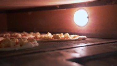 Fırın, hangi içinde ışık yanıyor ve pizza çeşitli daireler pişiren. Daire üzerinde domates Yapıştır ve mozzarella peynir kaplı. Pişirme sırasında buhar üretilir.