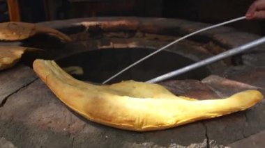 Aşçı geleneksel Gürcü ekmek - puri özel uzun bir sopa ile bir taş fırın dışarı alır ve yanındaki diğer ekmek fırın kenarına koyar. Ekmek uzun bir şekli vardır.