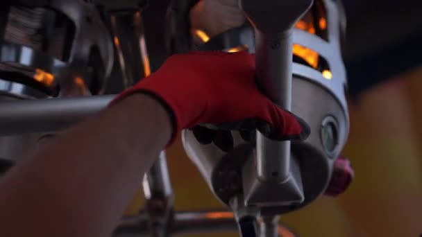 ボトムアップから黄色の光が金属バーナーのクローズ アップ 赤い手袋の労働者の手が金属の棒でバーナーを保持します — ストック動画