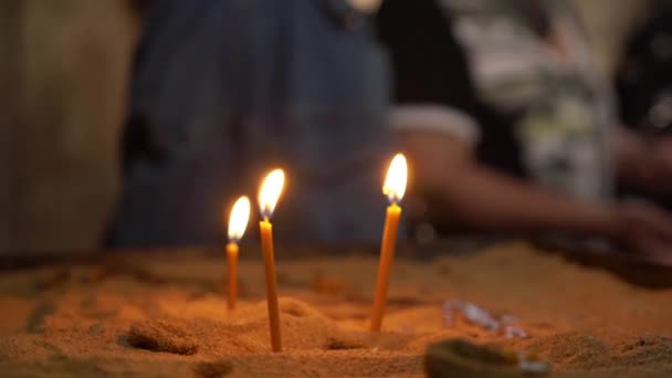 Drie Gele Aangestoken Kaarsen Staan Het Zand Vlam Van Kaarsen — Stockvideo