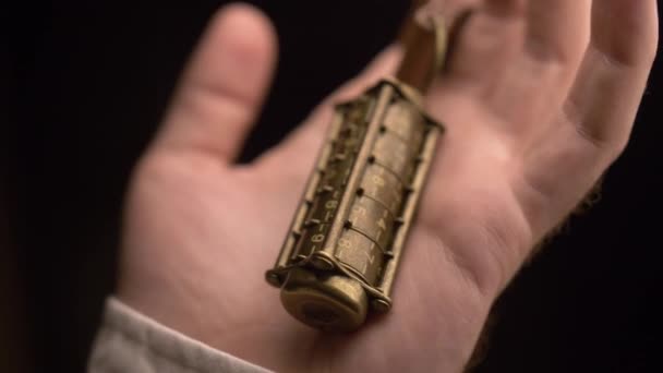 一个人检查一个铜金属密码与数字 戴在一个手指上 通过皮革表带 然后挤压他手中的密码 — 图库视频影像
