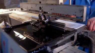 Fabrikada çalış. Sonunda küçük süngerler ile metal ve ahşaptan yapılmış kısmı mürekkep içine indirilir ve daha sonra özel olarak hazırlanmış plastik kareler içine harfleri aktarır.