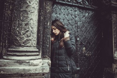 Genç kız eski Gotik duvar arka plan üzerinde duruyor.