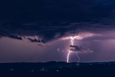 Fırtınaların arka planında gece manzarası. Kırsal siluet ve yıldırımlı bulutlar