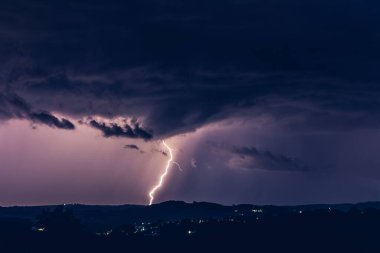 Fırtınaların arka planında gece manzarası. Kırsal siluet ve yıldırımlı bulutlar