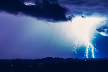 Fırtınaların arka planında gece manzarası. Kırsal siluet ve yıldırımlı bulutlar