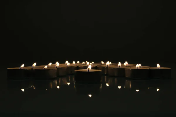 Candles burning in the dark. Tealight candles in the darkness