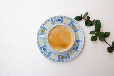 Bir kahve fincanı ve yeşil yaprakları ile şube kompozisyonu