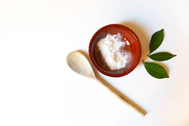 Beyaz kil, tahta kaşık ve yeşil l ile ev yapımı yüz maskesi