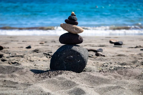 Balancing stones composition on the beach with the blue ocean ba — Stock Photo, Image