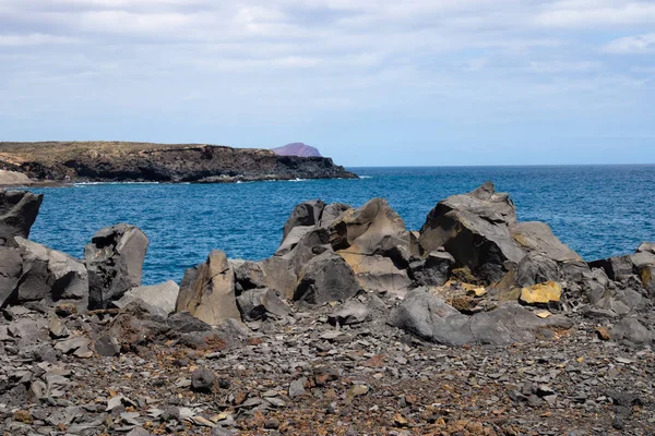 View at the ocean with the volcanic rocks and faraway island, Te — Stock Photo, Image