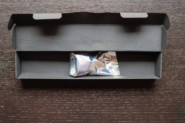 Masadaki kara kutunun içinde gümüş folyo şeker - Resim