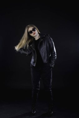 genç kız bir siyah deri ceket ve güneş gözlüğü üzerinde karanlık bir ba