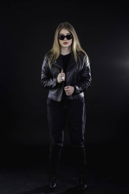 genç kız bir siyah deri ceket ve güneş gözlüğü üzerinde karanlık bir ba